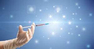 Female doctor hand holding syringe with shiny crosses in the background