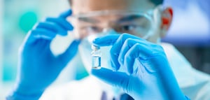 Man looks at sample wearing gloves and mask -stock image-min
