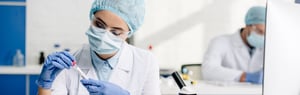 Woman in lab working with vial - stock image-min