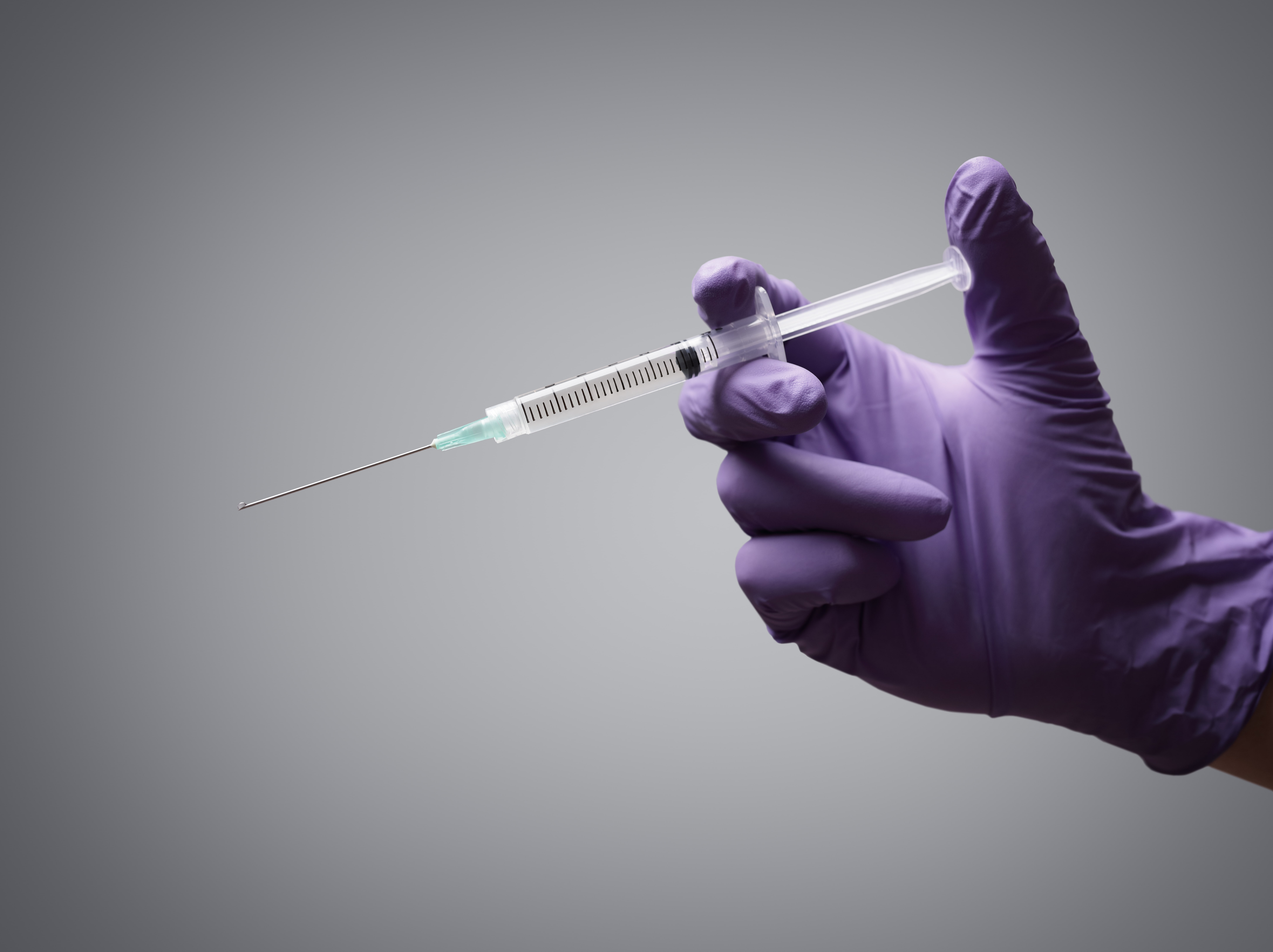 doctor-holding-medical-syringe-P8HB6XE-min