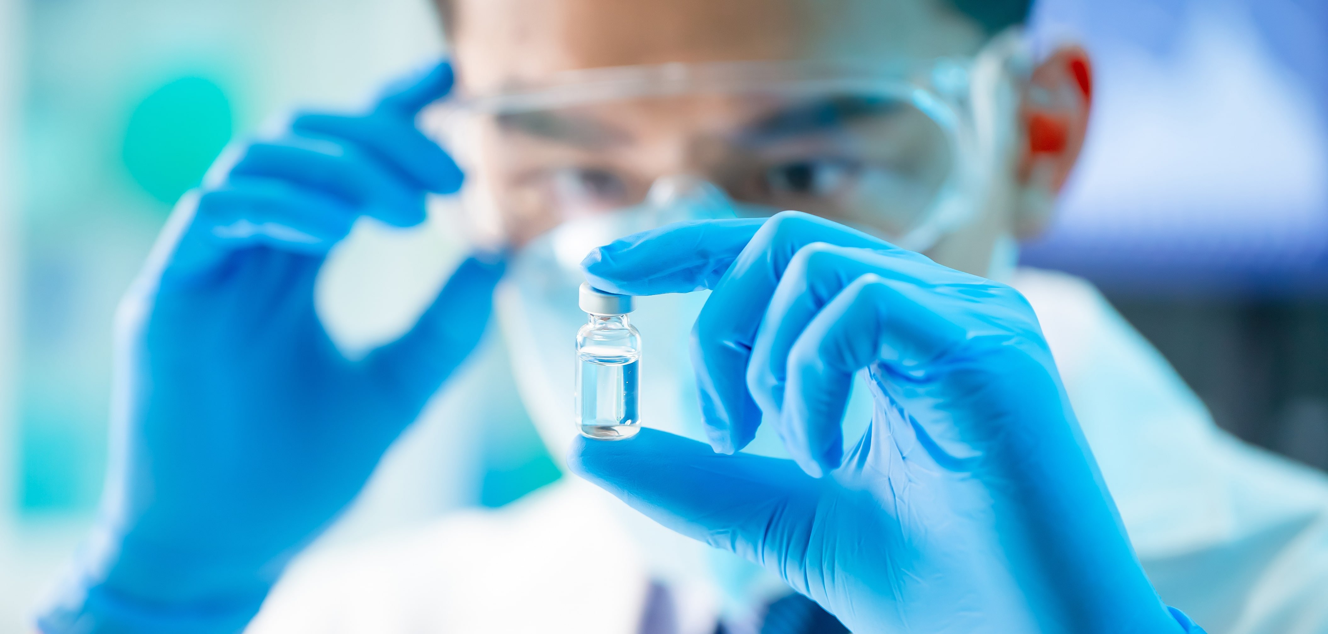 Man looks at sample wearing gloves and mask -stock image-min